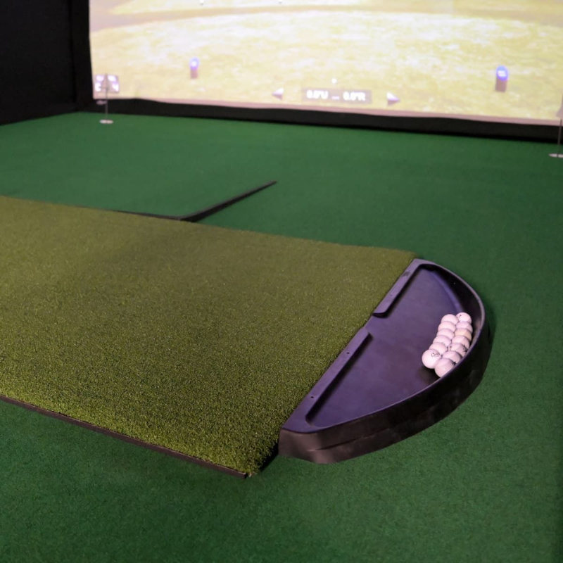 Carl's Place Golf Ball Tray inside golf simulator with mat and balls.