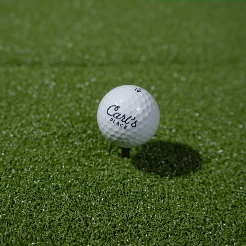 Carl's Place HotShot Golf Hitting Mat with golf ball and tee.