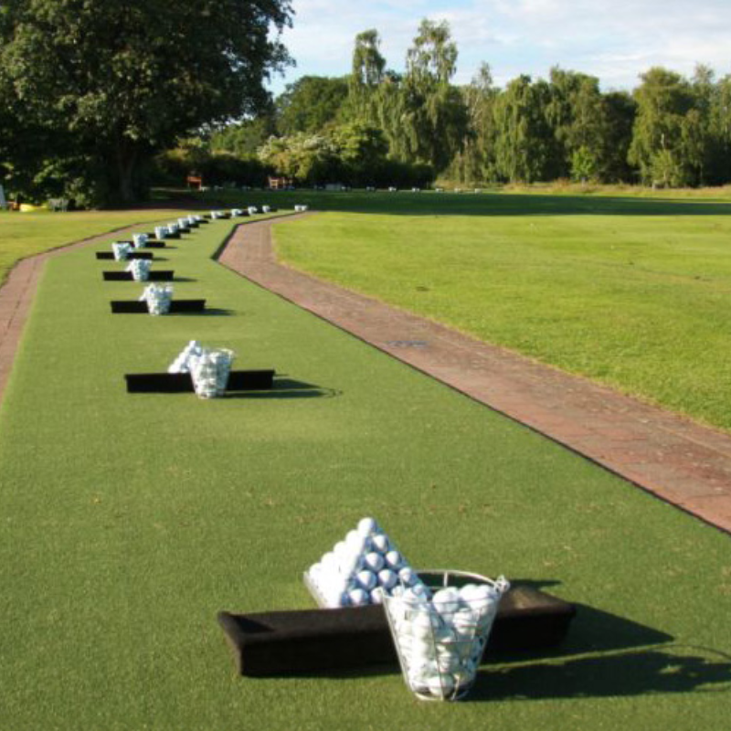 EZTee Poly Golf Hitting Strip and Tee Line Turf golf driving range setup with mats and ball baskets.