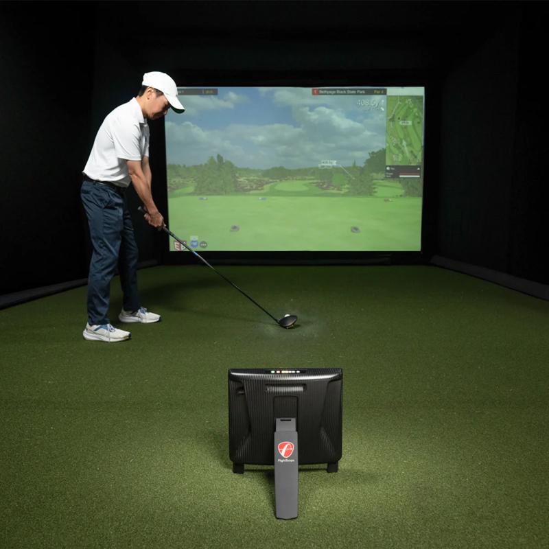 FlightScope XC3 Launch Monitor and Golf Simulator indoor setup with player and screen.