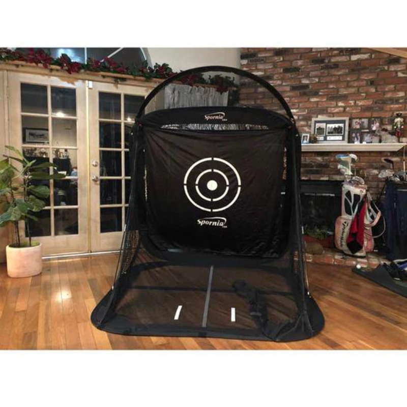 Spornia SPG-5 Golf Net indoors with golf clubs.