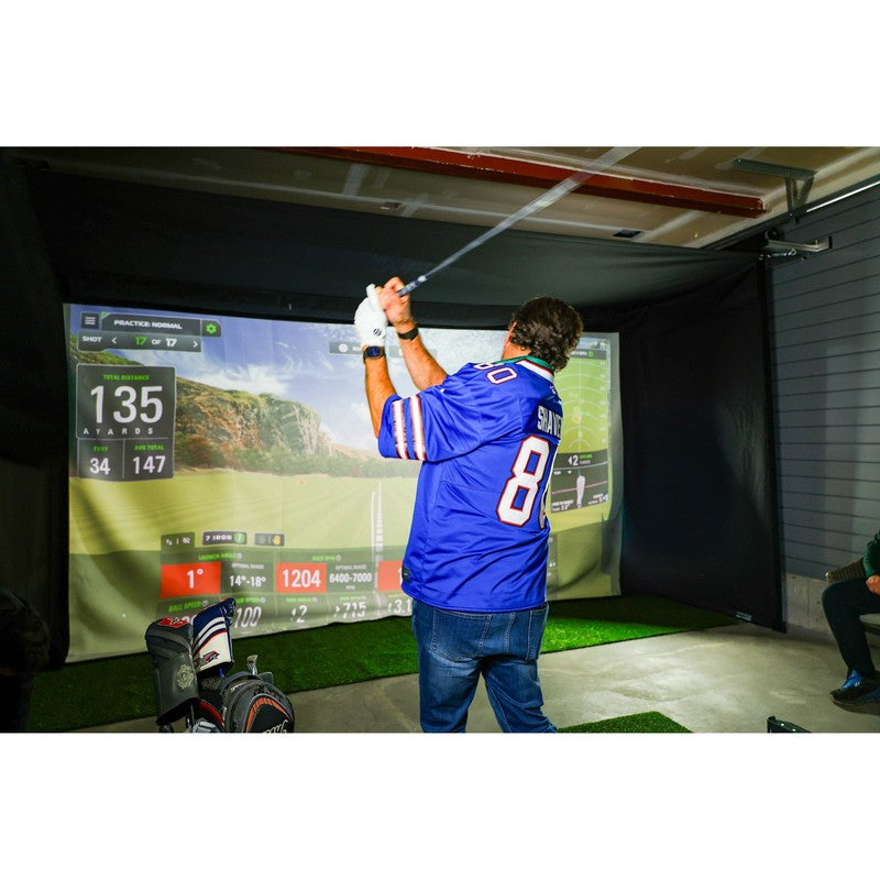 The SportsScreen Vanish Series Golf Simulator Enclosure golfer swinging in a garage.